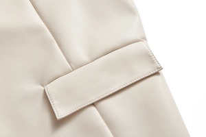 Détail de la texture cuir crème de qualité supérieure et coutures de poche sur la veste