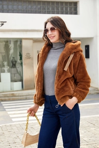 Detailed close-up of brown faux fur hooded jacket with soft plush texture and metal zipper