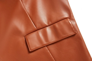 Détail de la texture en cuir PU caramel et couture précise sur la poche du gilet