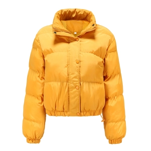 Detail of high-neck yellow puffer jacket with button closure and quilted texture