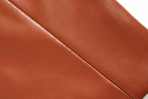 Vue macro de la texture en cuir PU marron grainé avec des détails de couture de haute qualité