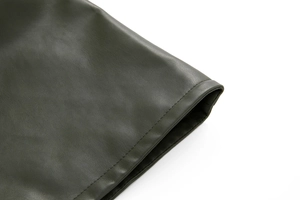 Detailed close-up of stitching and pebble grain texture on olive green PU leather shorts