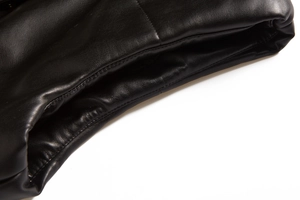 Detail of premium black leather vest showing fine grain texture and neat stitching