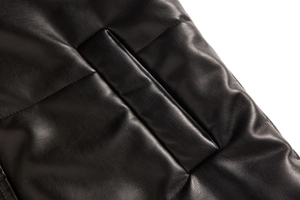 Detail shot of black leather padded vest showing fine quilting and premium texture