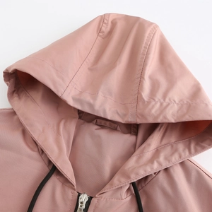 Detail of hood stitching and silver metal zipper on dusty pink windbreaker jacket