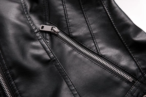 Close-up of litchi textured leather and silver metal zipper detail on black jacket