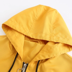 Detail of yellow windbreaker featuring silver ring zipper and black drawstrings