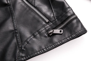 Detailed close-up of premium black faux leather texture with fine stitching and dual metal zippers