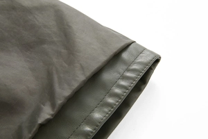 Detail of olive green PU leather hem with double stitching and smooth gray lining fabric
