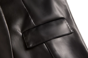Détail du gilet en simili cuir noir montrant les coutures de qualité et la poche à rabat