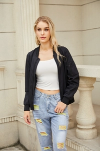 Detail einer lässigen schwarzen Bomberjacke kombiniert mit zerrissener Jeans im Streetstyle