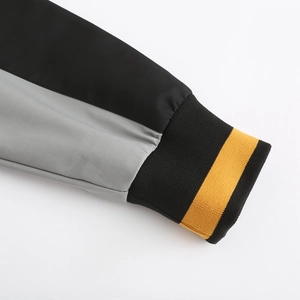 Detail of windbreaker ribbed cuffs in black with a vibrant yellow decorative stripe