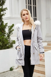 Detail of light gray parka coat showing the fluffy white faux fur hood and metal snap buttons
