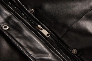 Detailed close-up of premium black leather vest featuring a silver metal zipper and snap button