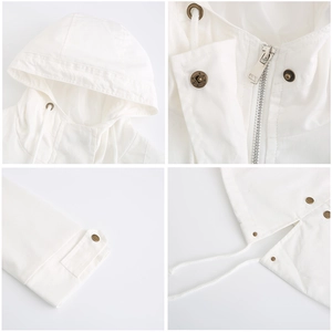 Detailed close-up of white hooded cotton parka showing metal zipper, snaps and drawstrings