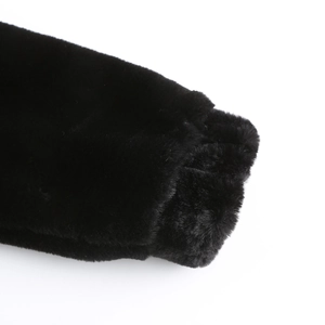 Close-up detail of soft black faux fur texture on long sleeve winter coat cuff