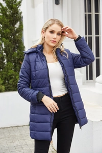 Outdoor shot of a woman in a navy blue quilted winter parka with a detachable hood
