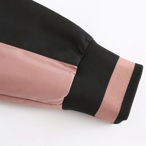 Close-up of pink and black color-block jacket sleeve with ribbed cuffs and fine texture