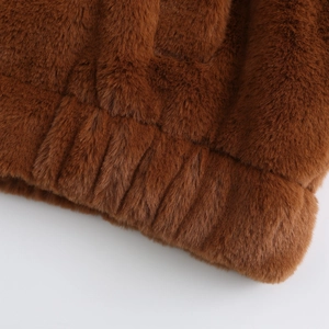 Close-up of thick brown faux fur jacket showing soft texture and elasticated hem details