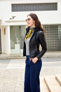 Detail of slim fit black faux leather jacket with removable hood and metal zippers