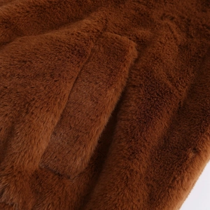 Macro detail of the plush brown faux fur texture and side pocket on this winter jacket
