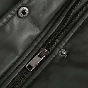 Detailed macro view of dark green leather texture with metal zipper and star embossed snap