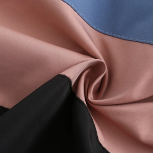 Detailed macro view of high-quality tricolor patchwork fabric in black pink and blue