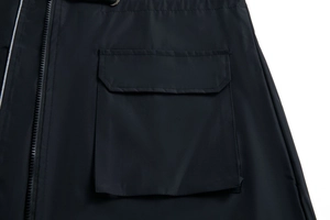Detail of waterproof trench coat showing large flap pocket and black zipper closure