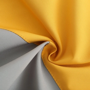 Close-up of contrast woven fabric in yellow and dark grey with detailed stitching
