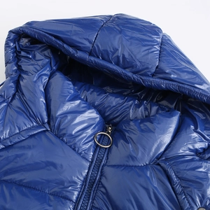 Detalle de chaqueta con capucha azul oscuro brillante y cremallera con anillo metálico