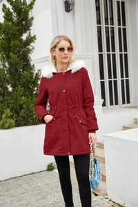 Detail of red winter parka featuring detachable fluffy white faux fur collar and drawstring waist