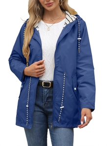 Detail of blue waterproof hooded windbreaker featuring striped lining and waist drawstring