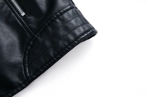 Detailaufnahme der schwarzen Lederjacke mit silbernen Reißverschlüssen und Ziernähten