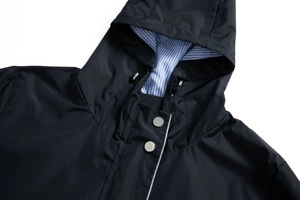 Detail of dark blue waterproof jacket with striped lining and silver metal toggles