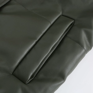 Detailed view of side pockets on dark green leather jacket with refined stitching