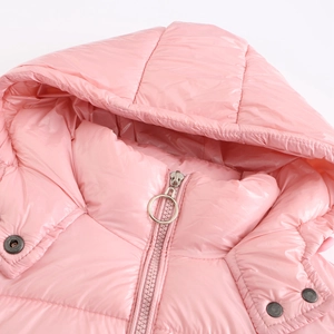 Detalle de chaqueta acolchada rosa con capucha mostrando tejido brillante y cremallera