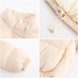 Detail view showing stand collar, elastic cuffs and drawstring hem of beige puffer jacket