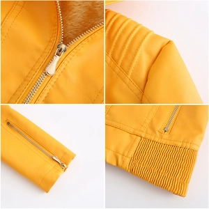 Detail view of yellow faux leather jacket showing zipper collar, quilted shoulder, and plush lining