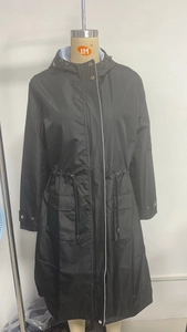 Detail view of water-resistant black trench coat with striped lining and drawstring waist