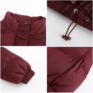 Detail view of wine red puffer jacket with snap buttons, drawstring hem and elastic cuffs