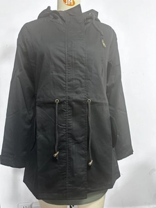 Detalle de la parka de algodón negro con cordón ajustable y cremalleras doradas