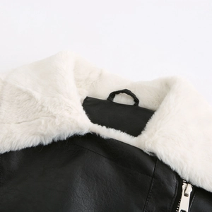 Détail de veste en similicuir noir avec col en fausse fourrure blanche et zip argenté
