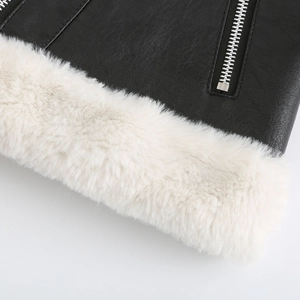 Détail du simili cuir noir avec doublure en fausse fourrure blanche et fermeture éclair