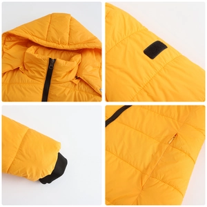 Detail view of yellow hooded parka showing ribbed cuffs, velcro patch and hidden zip pockets