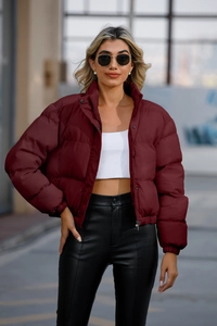 Detailed view of the dark red puffer jacket featuring a stand collar and metal button closure
