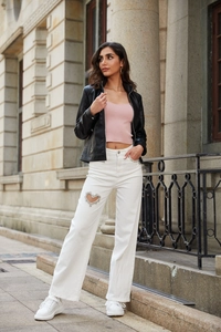 Outdoor street style view of a black leather jacket with a pink top and white heart-decor pants