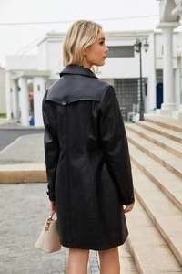 Detail of the back of a black long-sleeved PU leather trench coat with button accents