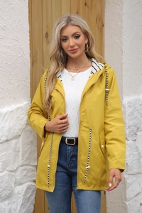 Detail of bright yellow waterproof raincoat featuring striped lining and adjustable drawstring