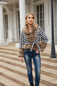 Detailed view of women's houndstooth jacket with brown faux fur collar and waist tie