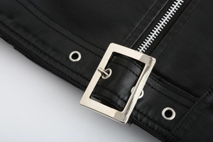 Detailaufnahme der schwarzen Lederjacke mit silberner Schnalle und Reißverschluss-Struktur